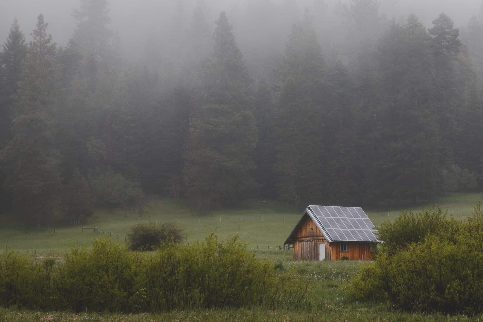 home in the woods off the grid with solar panels covering roof