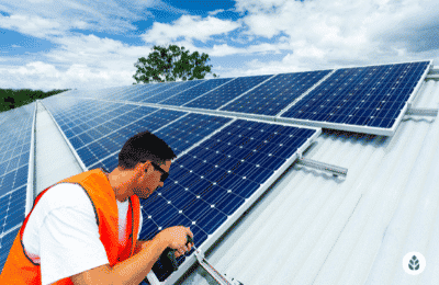 man in orange vest installing solar panels